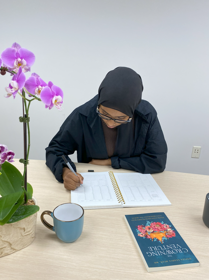 a lady writing something on The Crowning Venture Planner and Journal